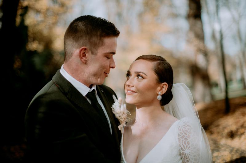 KWH real bride Rachel looking longingly at Josh. She wears the ivory Rylie gown, a modern lace long sleeve wedding dress