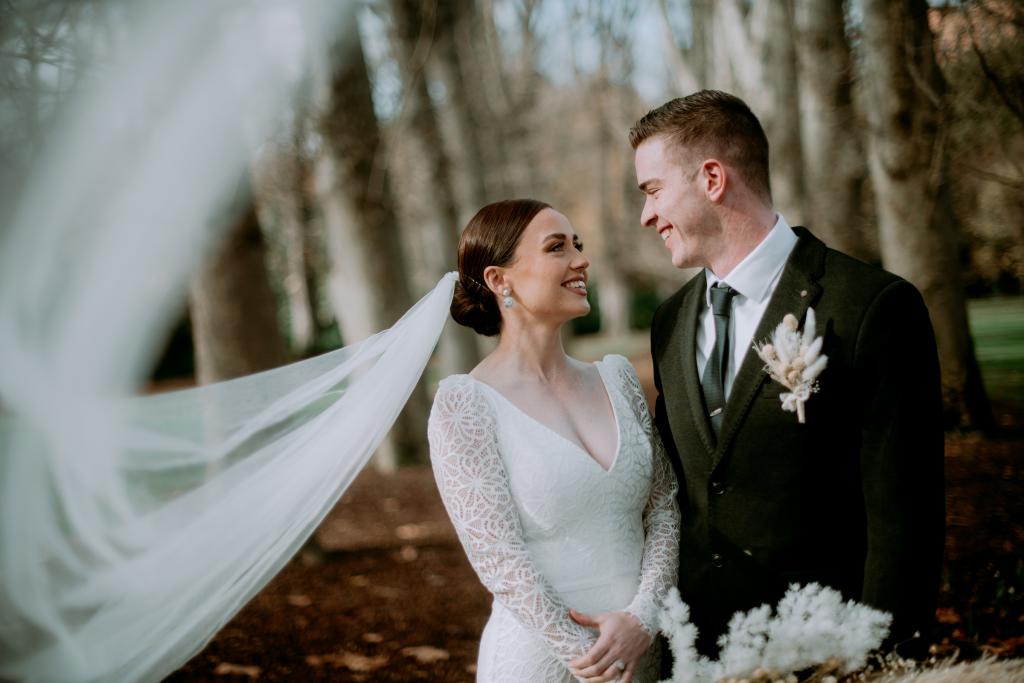 KWH real bride Rachel and Josh starring in each other's eyes. She wears the beautiful Rylie gown, a long sleeve lace wedding dress.