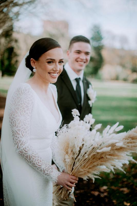 KWH real bride Rachel and Josh smiling at their elopement. She wears the Rylie gown, a v-neck fit and flare wedding dress