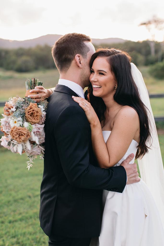 KWH real bride Hannah hugs Reece. She wears the Blake Camille gown, a modern strapless aline wedding dress.