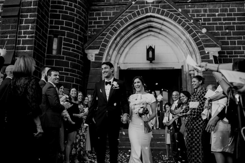 KWH real bride Jacqui stands at the altar with Chris as she wears the crepe Clarissa gown, a fit and flare cap sleeve modern wedding dress.