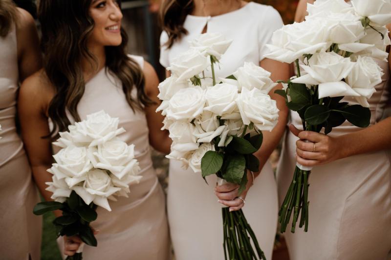 KWH real bride Jacqui has her bridesmaids help her put on her Clarissa gown, a minimalist fit and flare wedding dress.