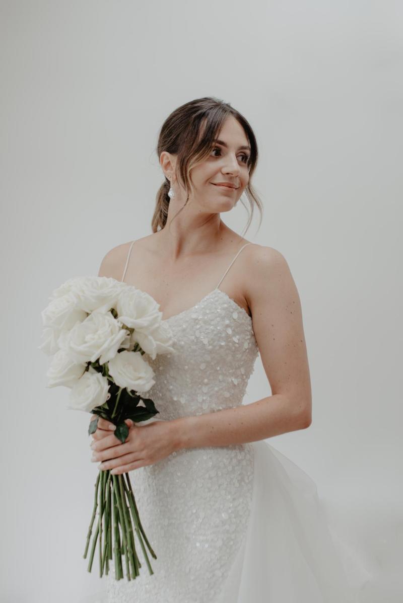 Bridal portrait of KWH real bride Monica standing in her Anya gown, a soft V-neck fiteed wedding dress with all over beads.