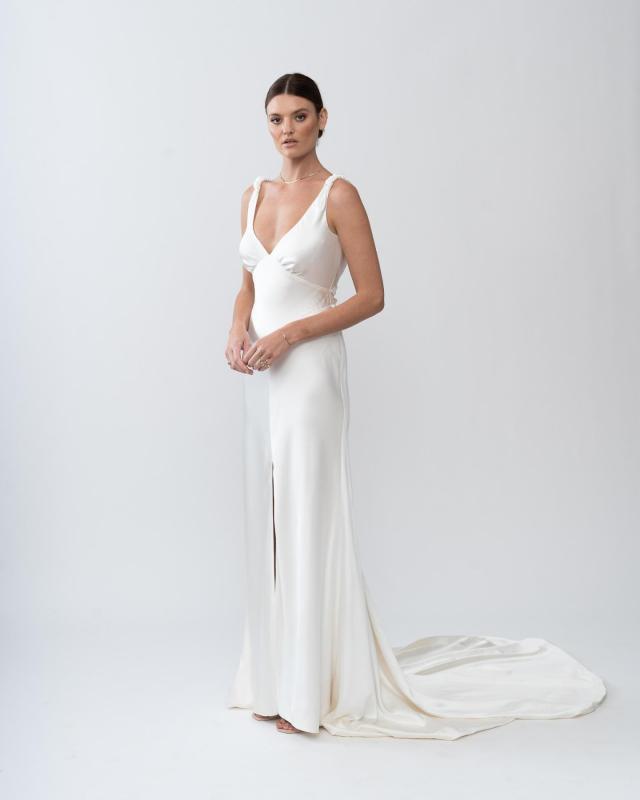The Athena gown by Karen Willis Holmes, a simple, V-Neck fit and flare satin wedding dress with dramatic train.