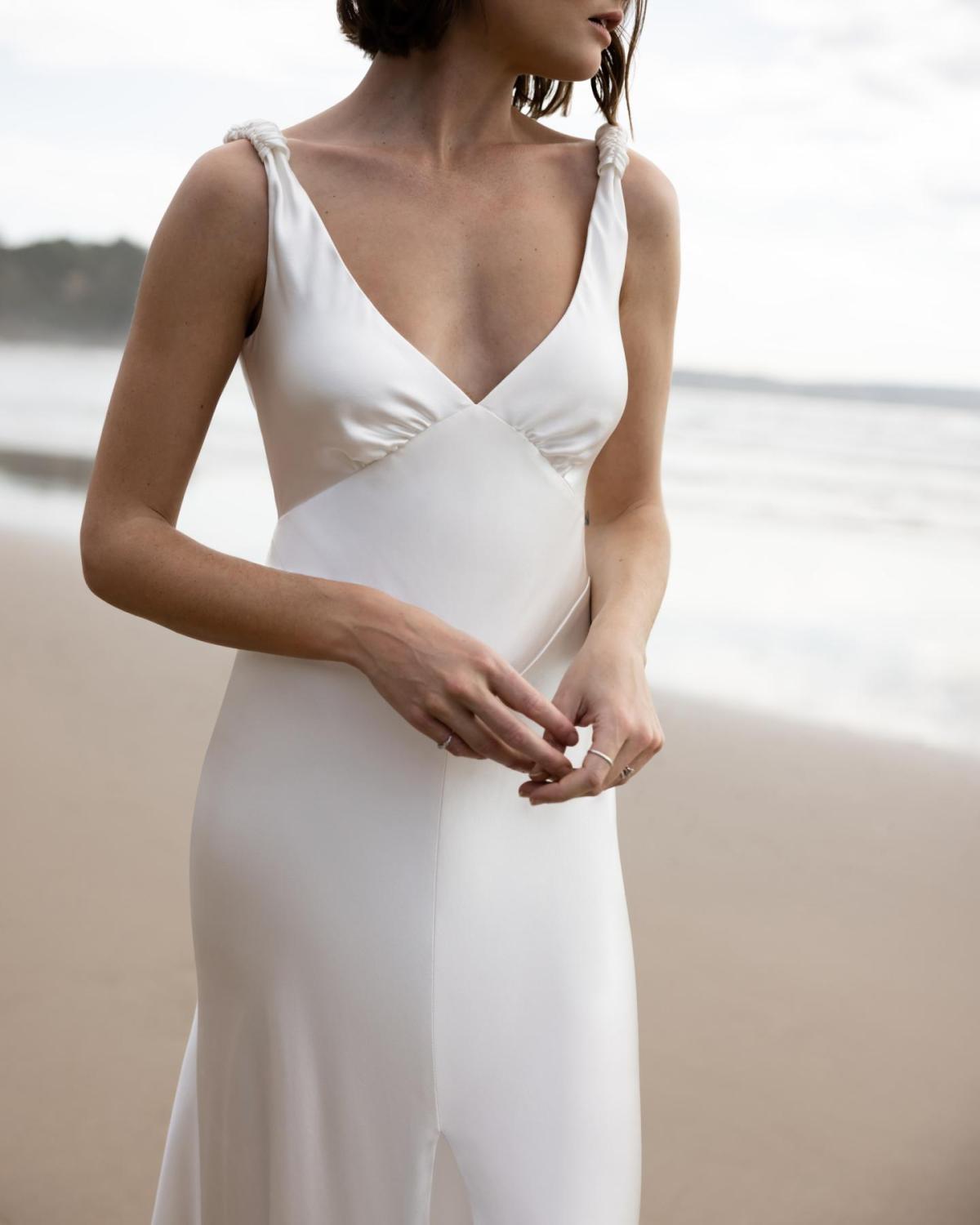 Upclose image of the Athena gown by KWH; a V-neck silk slip wedding dress with leg split and open back.