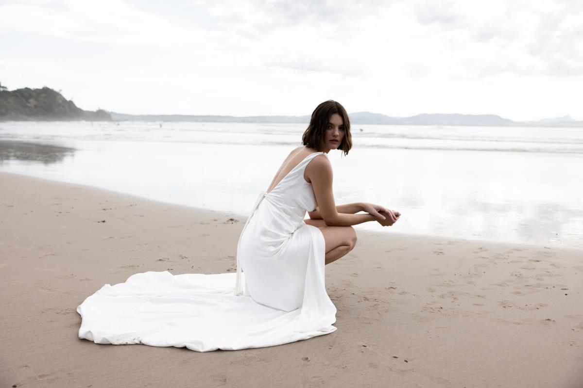 Upclose image of the Athena gown by KWH; a V-neck silk slip wedding dress with leg split and open back.