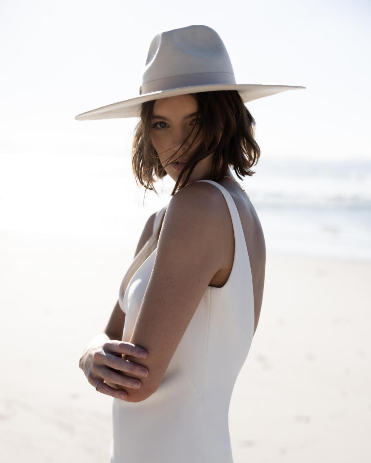 Upclose of the Shelby gown by Karen Willis Holmes, a simple slip crepe wedding dress with open back and paired with a felt hat.