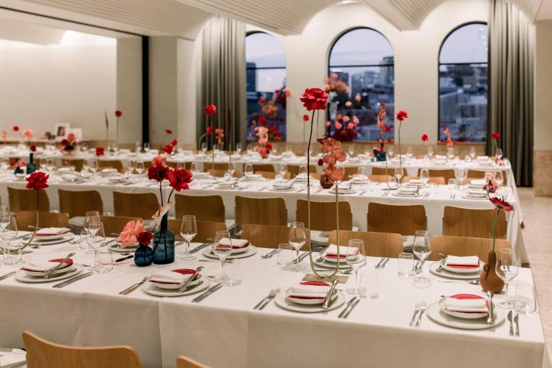 KWH real bride Josey's minimalist reception decor with terrocata bud vases and pops of bright red flowers.