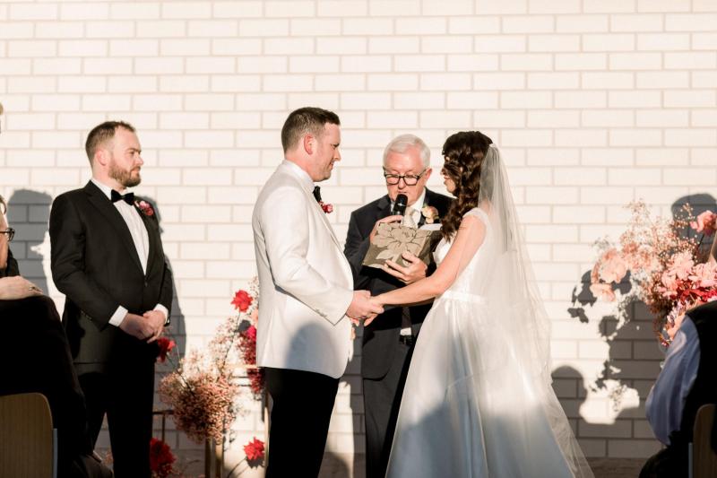 KWH real bride Josey and Brad kiss in front of the skyline as she wears the grand Taryn Camille gown, a modern aline wedding dress with U-shaped neckline.