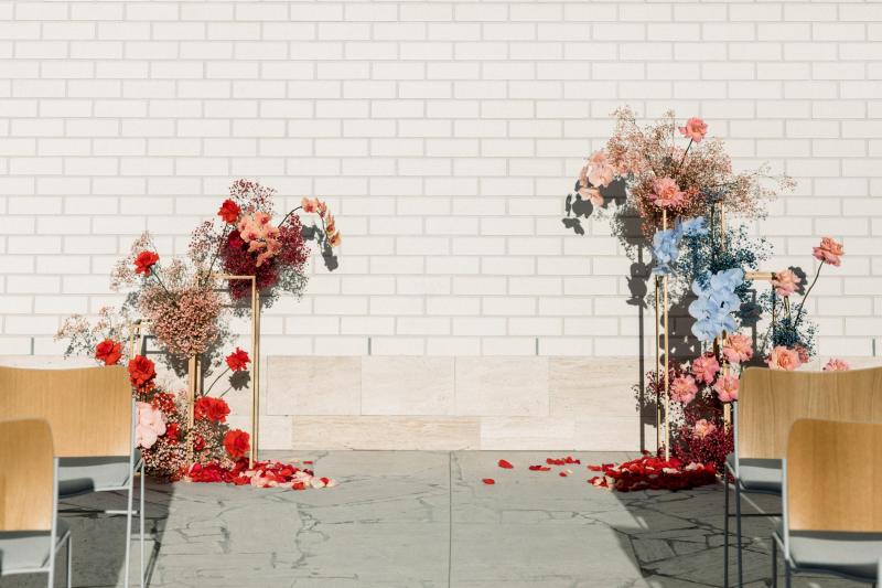 KWH real bride Josey's minimalist reception decor with terrocata bud vases and pops of bright red flowers.