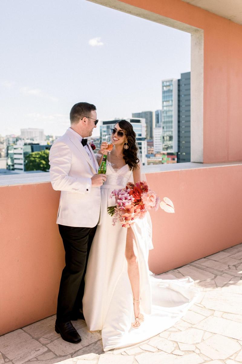 KWH real bride Josey looks at brad in her bridal sunglasses and Taryn Camille gown, a timeless aline wedding dress with pockets.