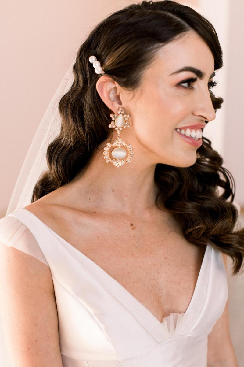 KWH real bride Josey showing off her Christie Nicolaides earrings in her Taryn Camille gown, a U-shaped neckline wedding dress with aline skirt.