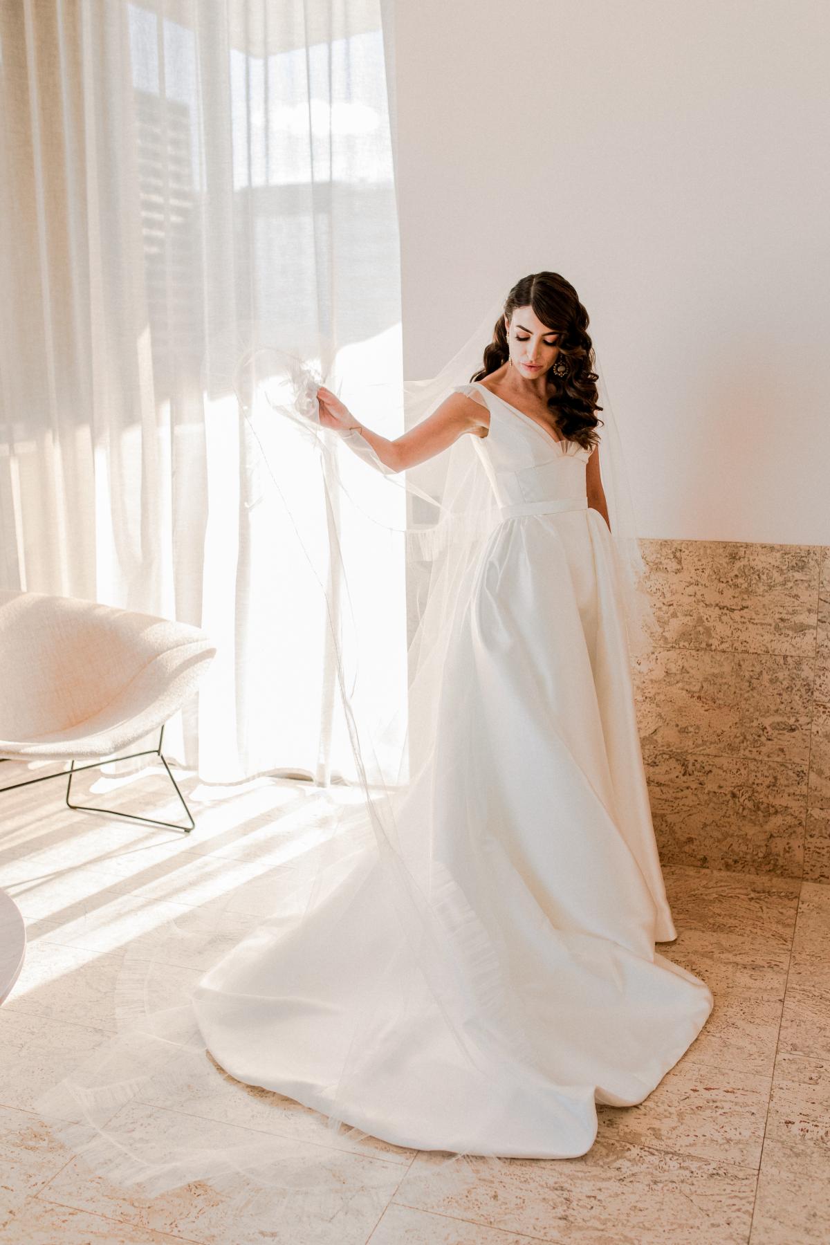 KWH real bride Josey struting in her Taryn Camille gown as she gets ready at The Calile Hotel. Taryn Camille is a voluminuous aline wedding dress with U-shaped wedding dress.
