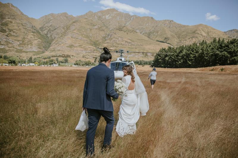 Olive by Karen Willis Holmes, which has a timeless look while giving a unique statement, as seen on one of our beautfiul brides while running through the fields towards a helicopter