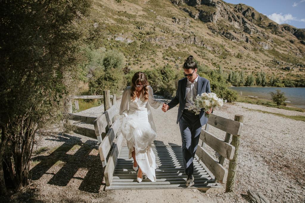 Olive-by Karen Willis Holmes. Bride holds onto her gorgeous train while her and her groom adventure around the lakes of New Zealand