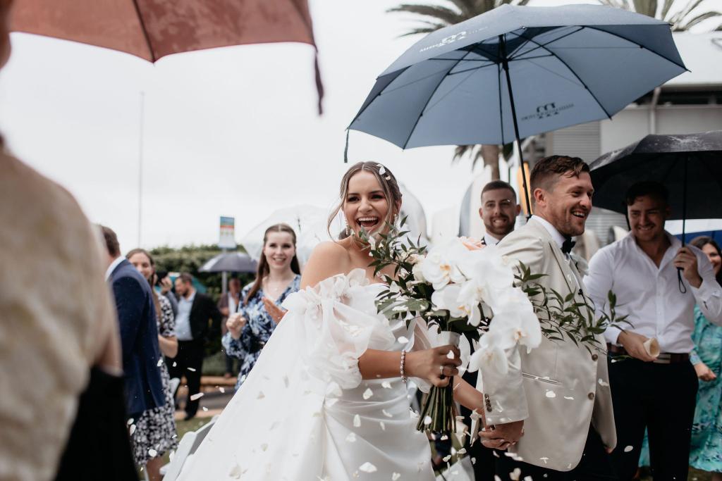 CATALINA - Karen Willis Holmes - Jessica & Nick - Bride and groom finalizing their vows and celebrating their marriage with rose petals thrown everywhere. Our Catalina Gown has a Dramatic beauty in each element on this stunning, satin-finished gown.