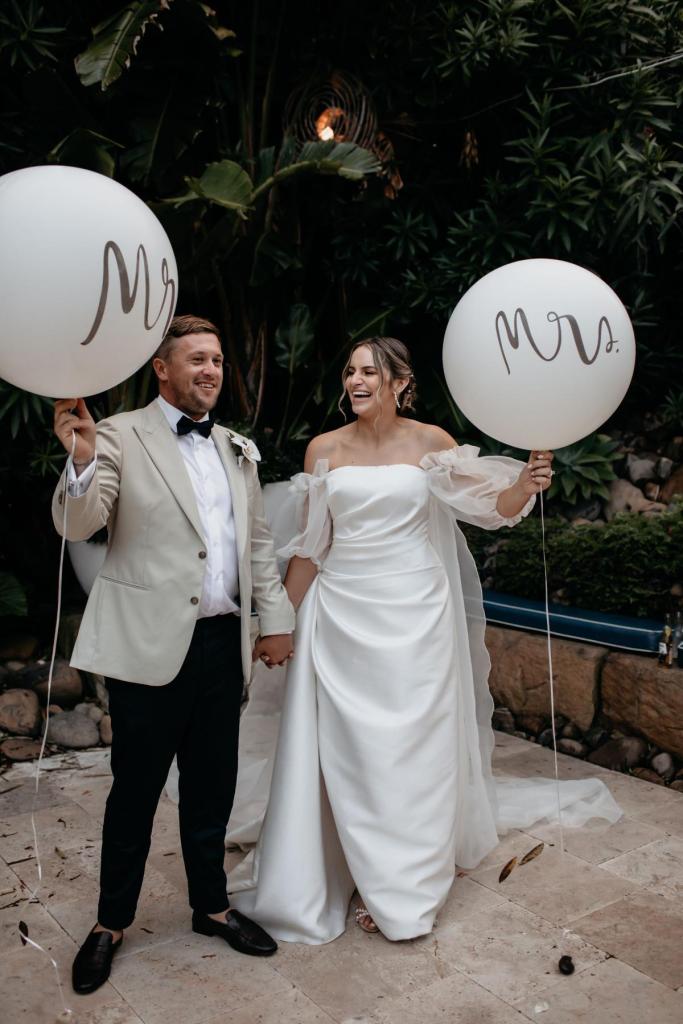 CATALINA - Karen Willis Holmes - Jessica & Nick - Wife and Husband hold Mr & Mrs balloons at their wedding reception to add a fun element to their celebration