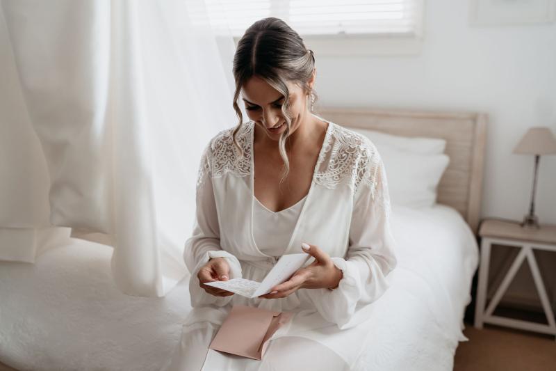 CATALINA - Karen Willis Holmes - Jessica & Nick - Bride reads a love letter from her future husband before she gets ready in her timeless Catalina gown from the BESPOKE colection. Perfect for our brides wanting that timeless yet chic bridal look.