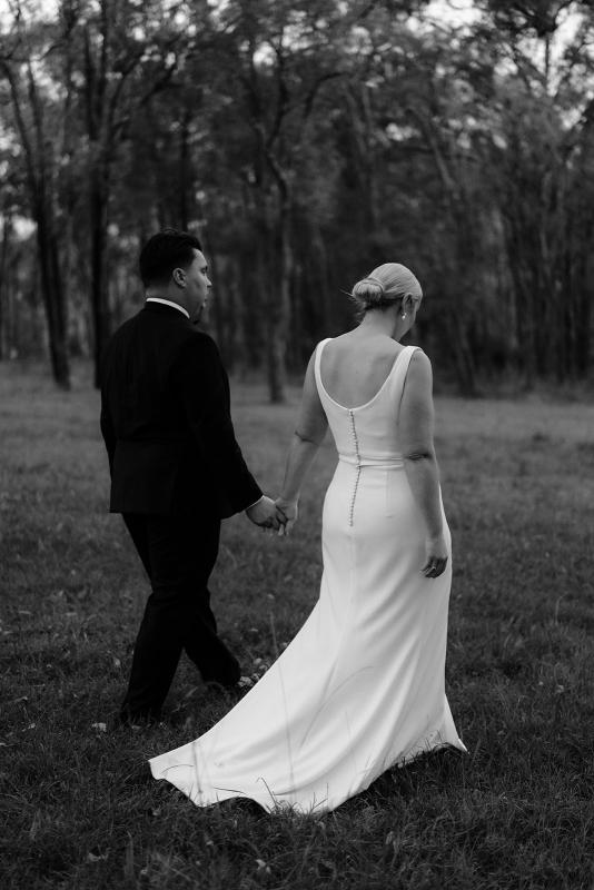 Nikki-Karen Willis Holmes- Bride and Groom wonder off, holding hands while bride wears a v-neck causal wrap wedding dress with split