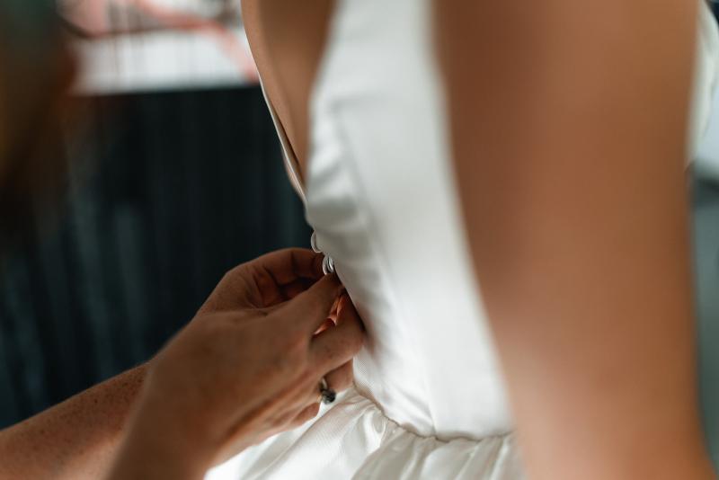 Taryn Camille_Karen Willis Holmes_Emma & Emily - Bride emily seen getting ready in her Taryn and Camille gown, our Taryn and camille beautifully display your décolletage and a classic full skirt with a side split make this gown the perfect juxtaposition of classic and edgy