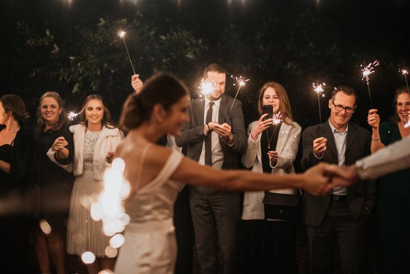 Tiffany-ELOPE-Karen Willis Holmes-Este & Wesley- Bride and groom celebrating their love and marriage after their ceremony with their family and friends, surrounded by sparklers to create the perfect romantic moments.