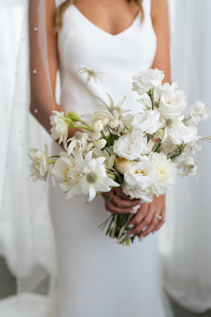 Shelby-Karen Willis Holmes - bride is seen holding her classic off-white flower bouquet with her timeless Shelby gown from the ELOPE collection.