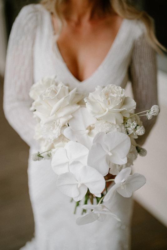 Perry Gown-Karen Willis Holmes-Kali & JR- Bride holding a bouquet of soft whites and green florals