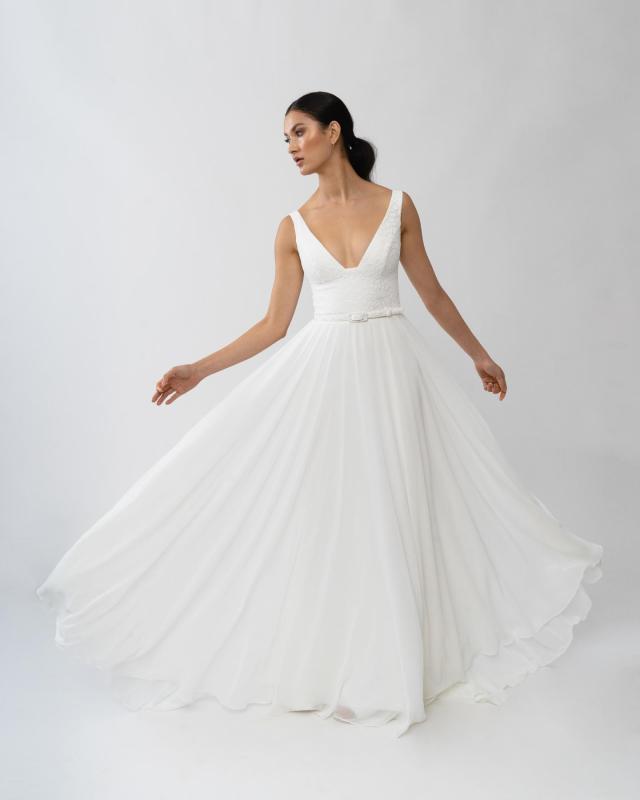 The Dixie gown by Karen Willis Holmes, a plunging neckline wedding dress with an A-Line skirt.