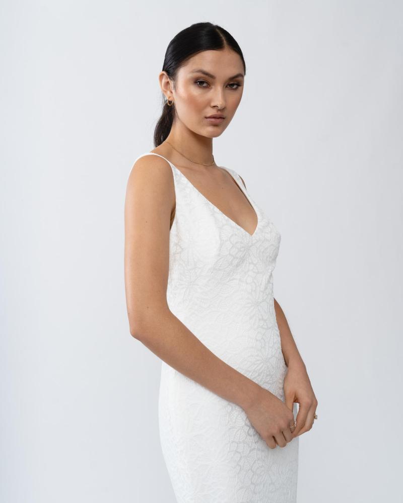 The Gigi gown by Karen Willis Holmes, a V-Neck, simple lace wedding dress with a fit and flare shape and an open back.