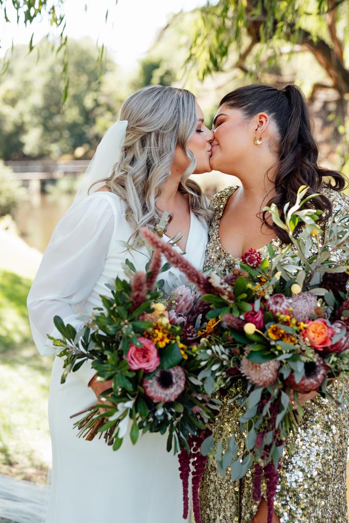 Nikki - Karen Willis Holmes - Sarah & Gabriella- LGBT wedding, bride is seen wearing the Classic Nikki gown from the WILD HEARTS collection from Karen Willis Holmes. bodice features a V-neckline and soft draping which continues into the wrap style skirt.
