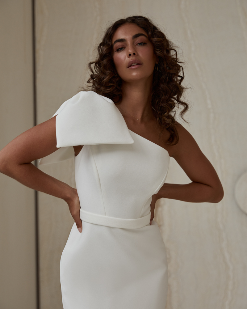 Lillian is a minimalist wedding dress for the classic modern bride featuring an asymmetric one shoulder design with detachable bow by Karen Willis Holmes 2023 Bridal Campaign