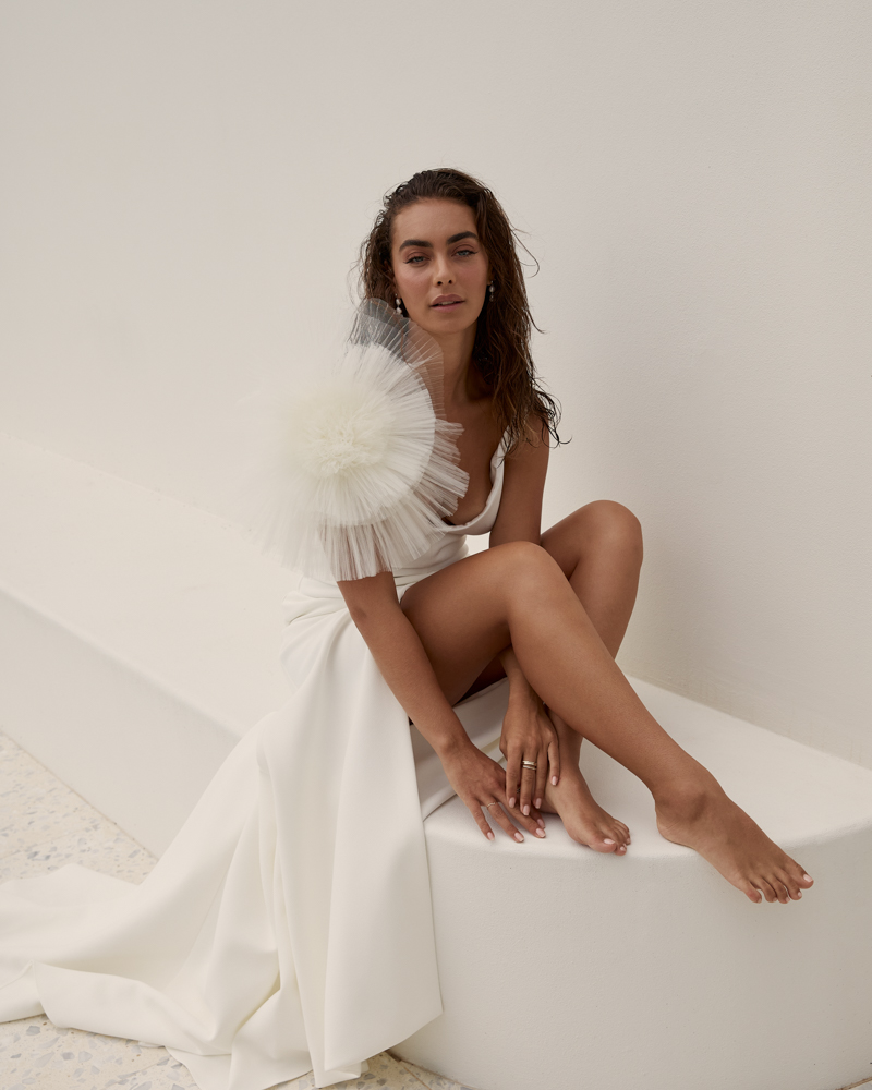 The Shelby wedding dress with a centre split featuring removable tulle flower shoulder corsage by Karen Willis Holmes 2023 Bridal Campaign