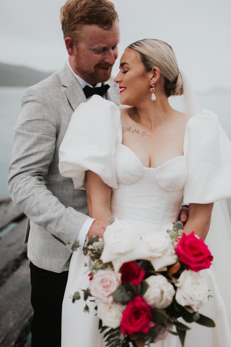 Bride wears Blake & Camille wedding dress by Karen Willis Holmes, an elegant ballgown with corseted bust cups, a full skirt with pockets and feminine bubble sleeves.