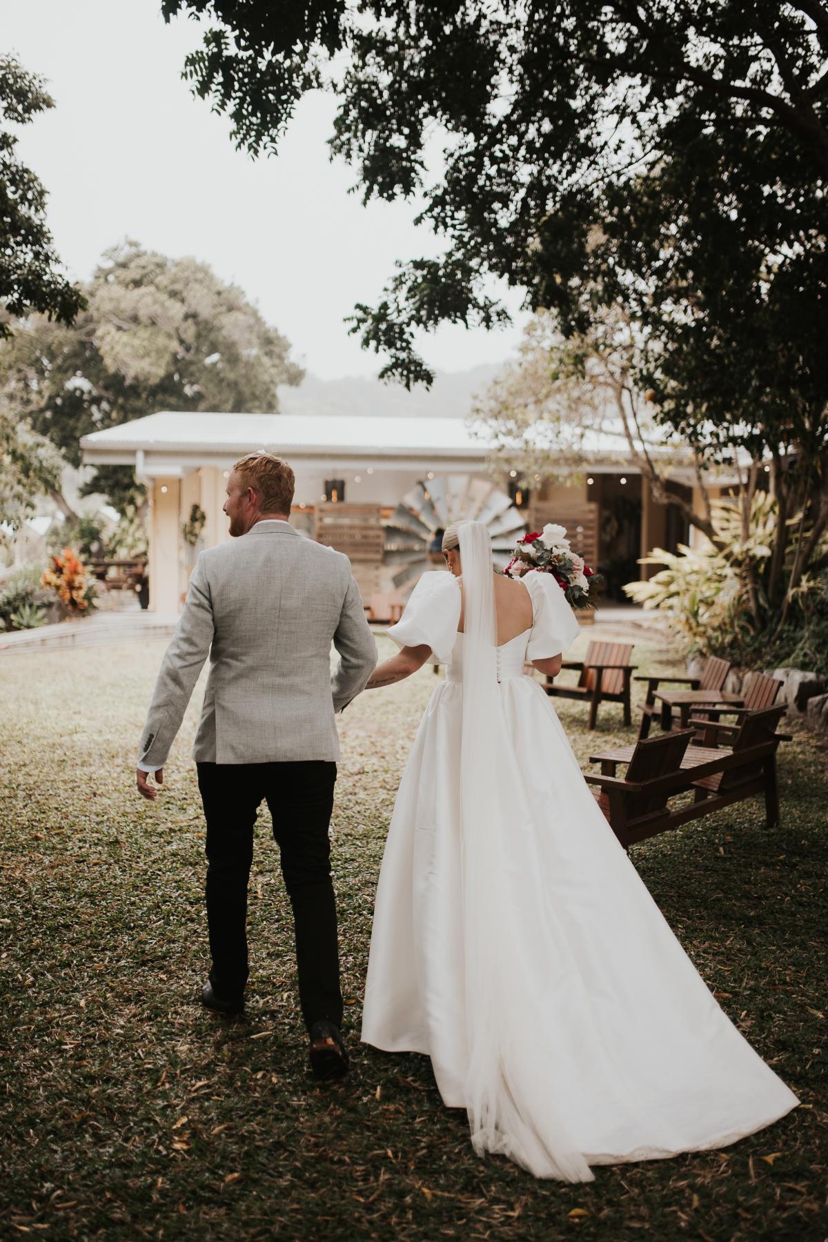 Bride wears Blake & Camille wedding dress by Karen Willis Holmes, an elegant ballgown with corseted bust cups, a full skirt with pockets and feminine bubble sleeves.