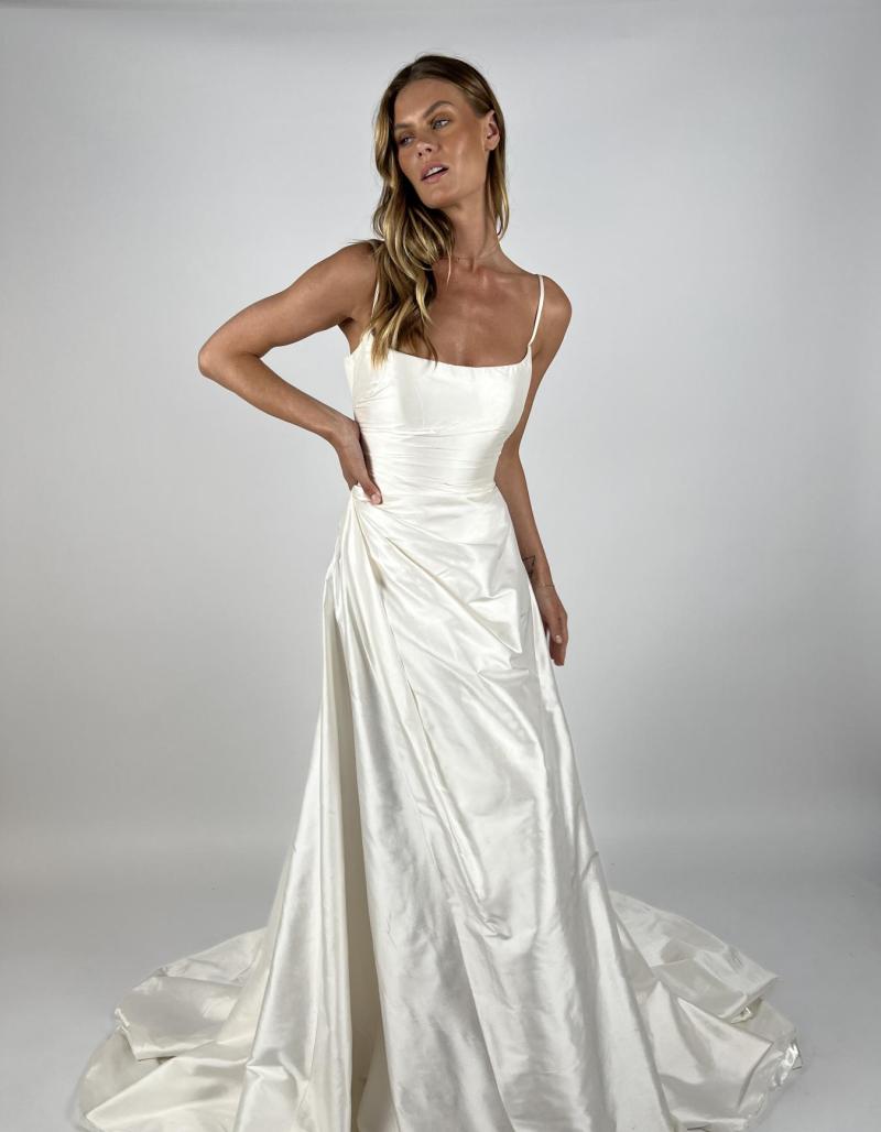 Emma wedding dress made from Silk Shantung. Spaghetti strapped scoop neckline bridal gown. Aline skirt with draping skirt with split.