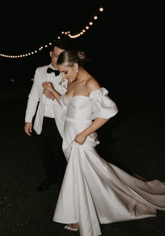 Jenna wears the Blake & Prea wedding dress by Karen Willis Holmes, a bustier fit and flare dress that provides structure and modern style.