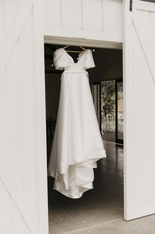 Chessy wears the Taryn & Camille wedding dress by Karen Willis Holmes, a U neck ballgown with a full skirt with pockets.