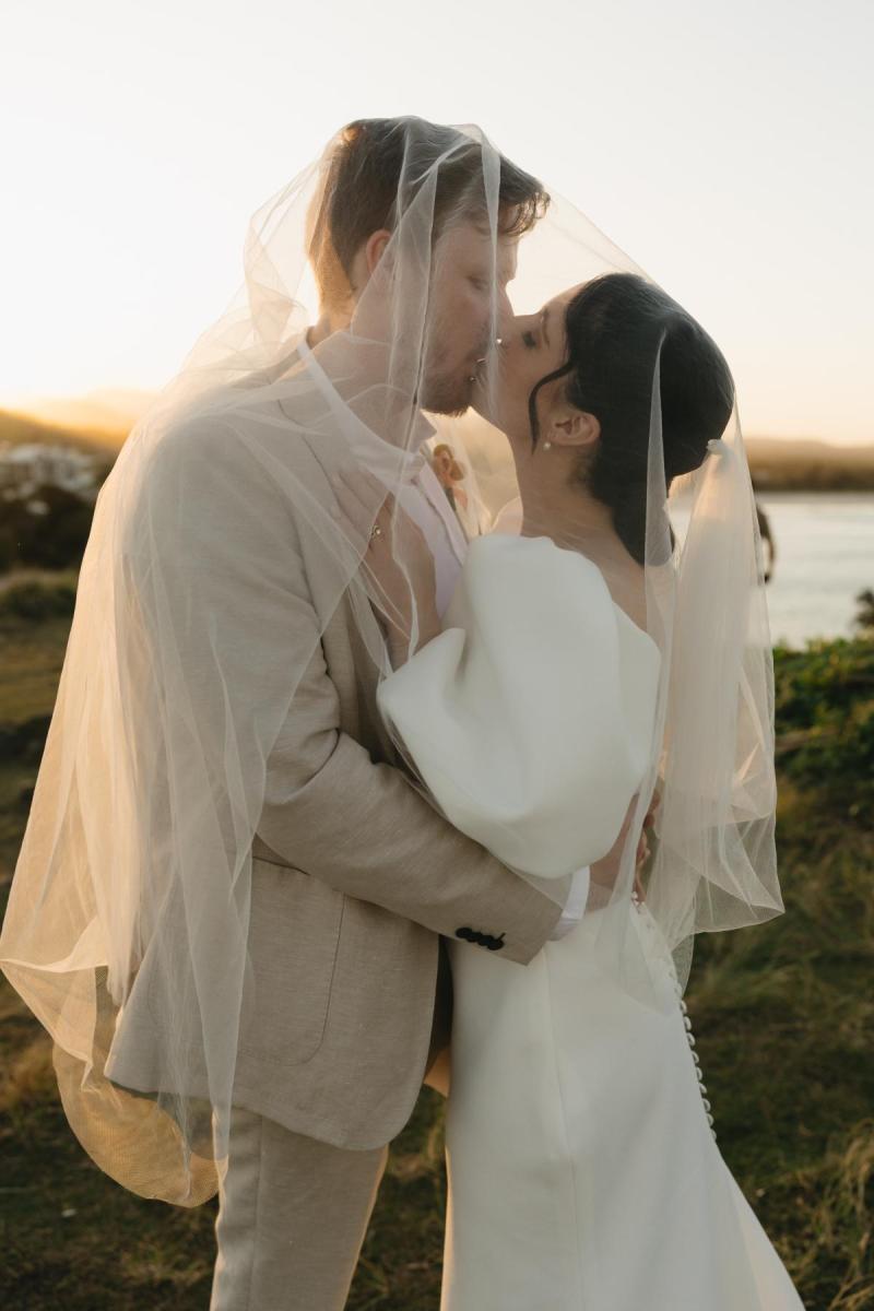 The Shelby wedding dress by Karen Willis Holmes is a sheath cut simple classic gown with a V neck, low back and statement bubble sleeves.