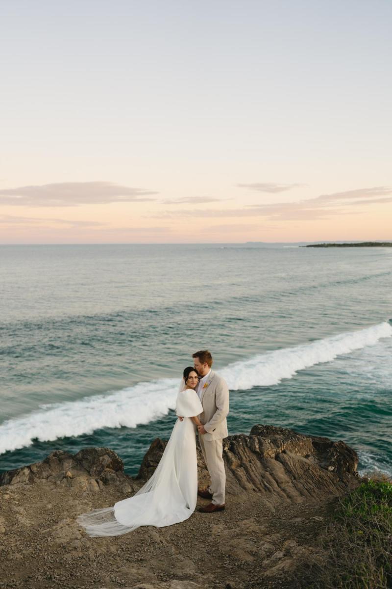 The Shelby wedding dress by Karen Willis Holmes is a sheath cut simple classic gown with a V neck, low back and statement bubble sleeves.