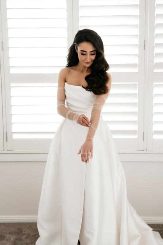 The Lou-Lou & Elizabeth wedding dress by Karen Willis Holmes is a strapless draped bodice with a full skirt including pockets & a statement split.
