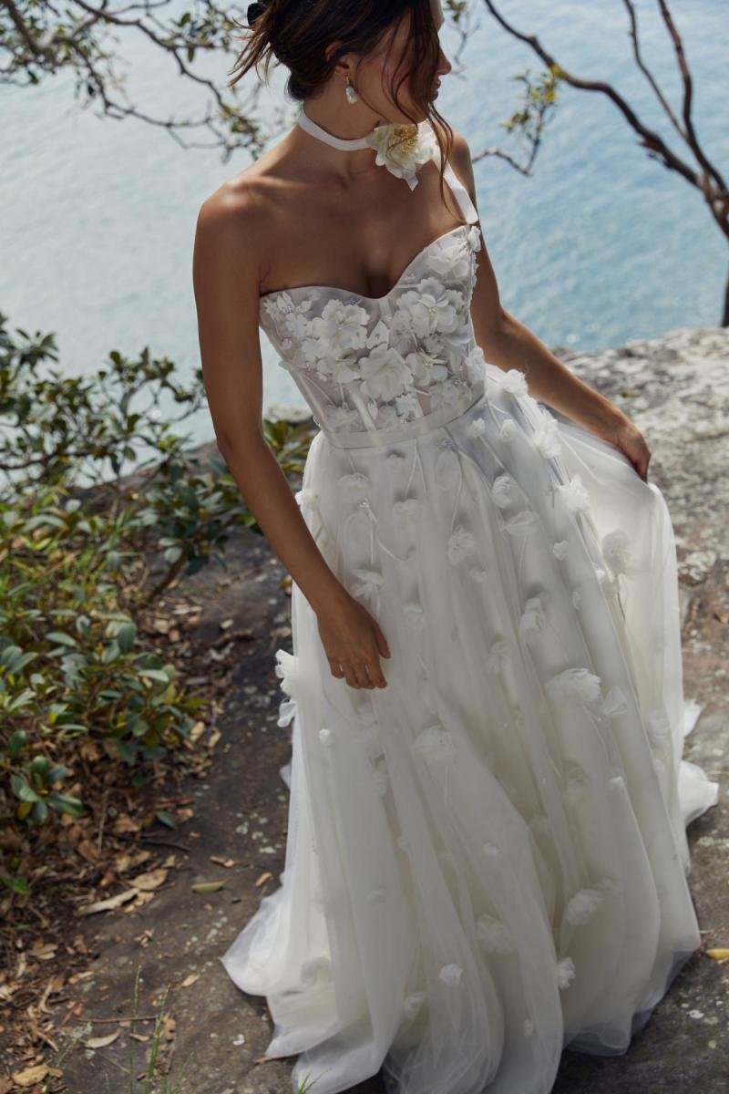 Gabriella is a wedding dress that exudes romance. Gabriella Features a corseted sweetheart Bodice with built in cups, and hand embroidered floral detail, and a soft tulle A-line skirt.