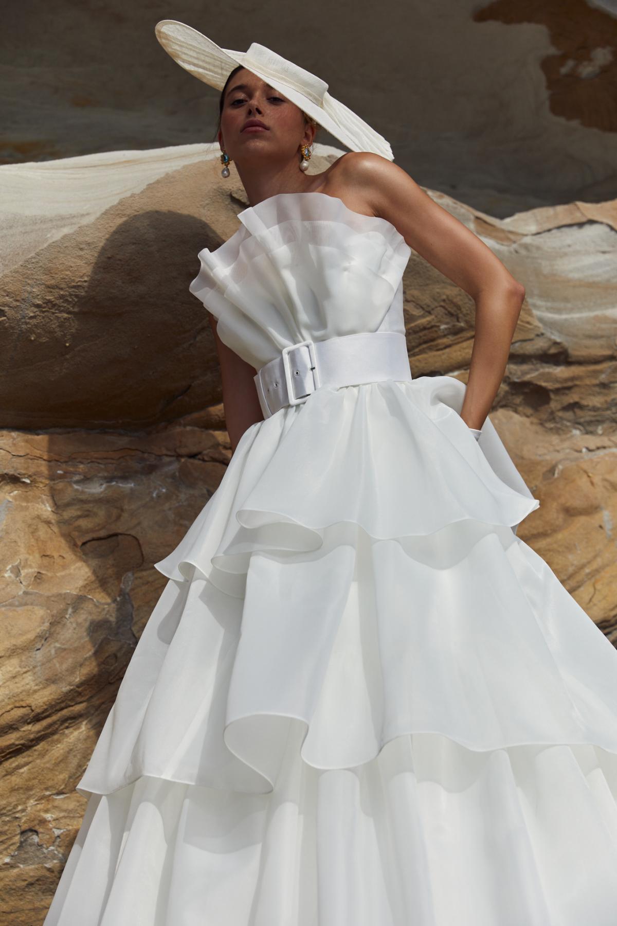 The Phoebe & Mila is the ultimate sculptural wedding dress. The Phoebe Bodice features a stunning hand draped Organza fan paired with the Mila Skirt which features multiple layers of organza.