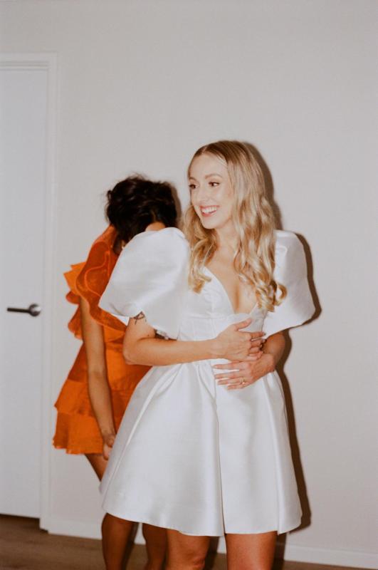Taryn Camille Mini with bubble sleeve and susan bow - Karen Willis Homes - Molly & Jay - Bride is wearing a classic wedding dress, the Taryn Camille Mini gown from the Bespoke bridal collection, the perfect balance s sophisticated and elegant wedding dress.