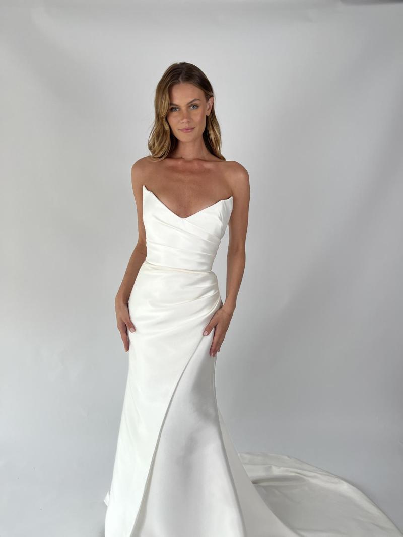 The Alissa & Emily wedding dress by KWH Bridal is for the dreamy bride. The Alissa Bodice features stunning hand draping, with a plunging pointed neckline to highlight your décolletage. The Emily skirt is a fit and flare draped skirt with an elegant split