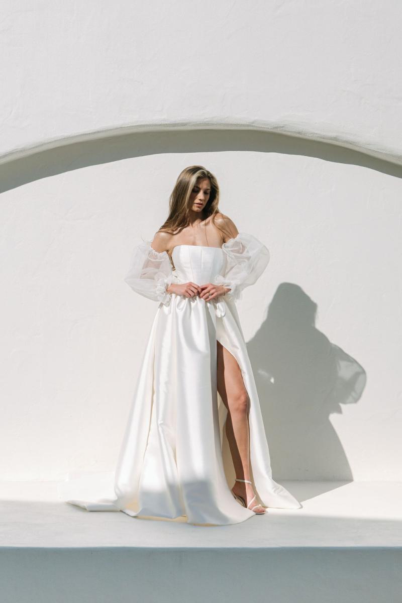 The Diana & Julianne by Karen Willis Holmes, a simple, straight neckline wedding dress with a traditional princess pleated skirt with pockets