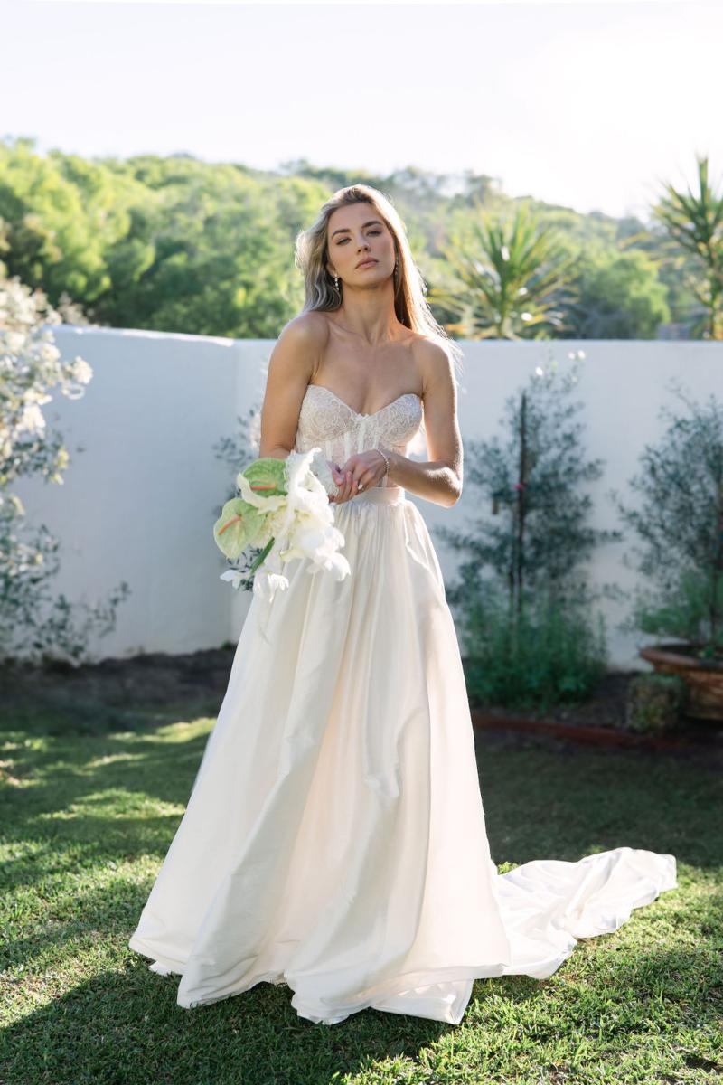 Eden & Julianne is the ultimate romantic wedding dress. With a perfect mix of drama and elegance. The Eden Bodice is soft yet structured, with hand draped corded lace and pearl detailing over a sheer corset. While the Julianne skirt in our exquisite silk shantung fabric adds refinement and a timeless touch. Photography by Daina Hazel