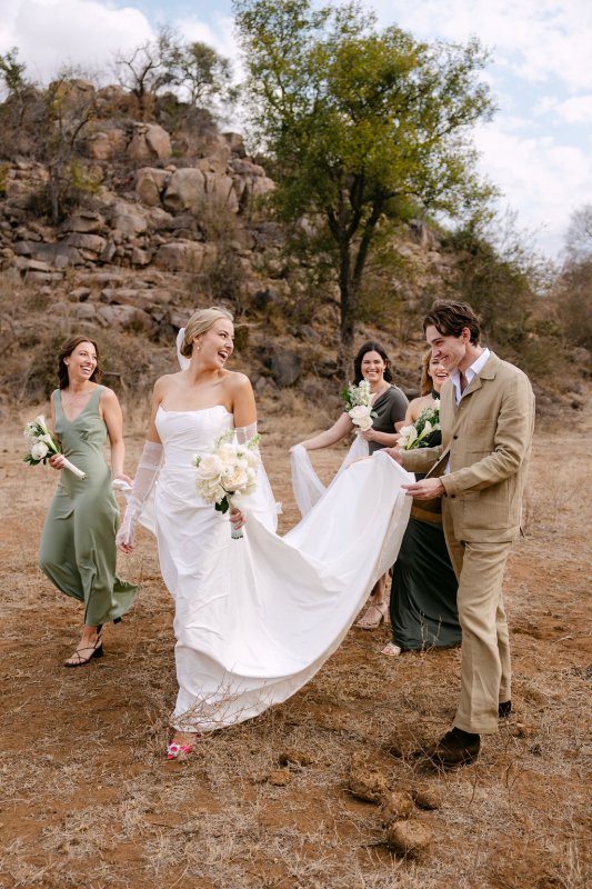 Bride and Bride's maids walking towards the ceremony, she is wearing our beautiful Emma gown, Erin's gloves and Pearl Graded veil.